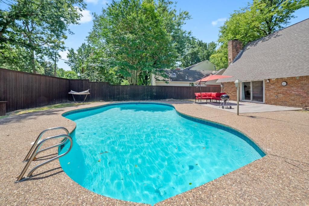 a swimming pool in a backyard with a fence at Close to St. Francis Hospital • 4 Smart Tvs • Pool • Patio in Tulsa