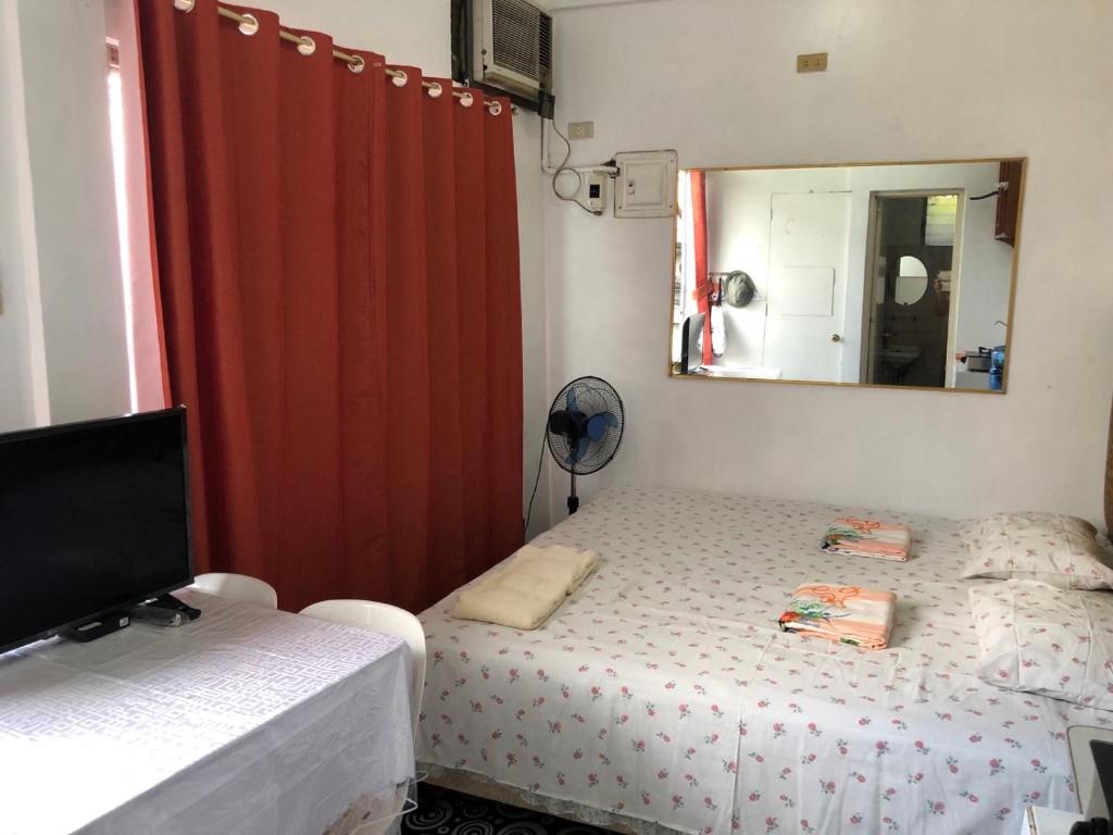 a small bedroom with a bed and a mirror at THE MANSION - 2 PAX SOLO BUDGET Room near AIRPORT TERMINAL in Manila