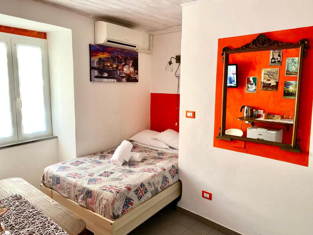 - une petite chambre avec un lit et un miroir dans l'établissement Affittacamere Rio Centrale, à Riomaggiore