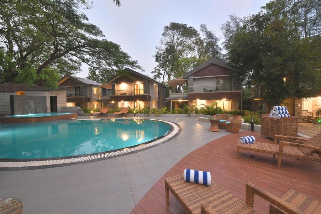 a backyard with a swimming pool and a house at Arova Woods Zinc Journey by The Fern, Lonavala in Lonavala