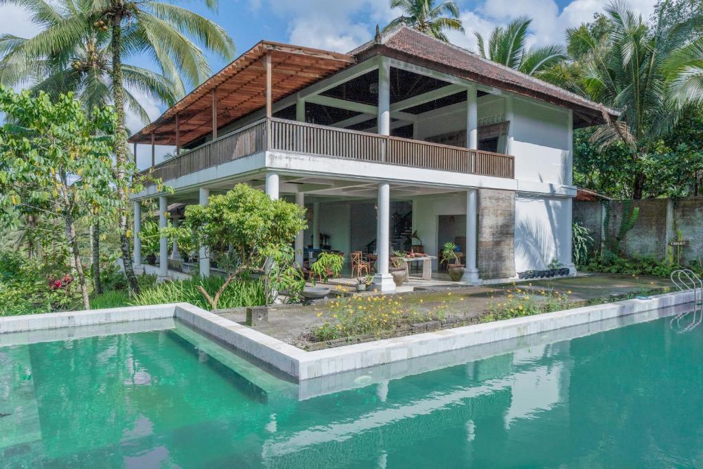 Villa con piscina frente a una casa en Galalima Glamping en Tabanan