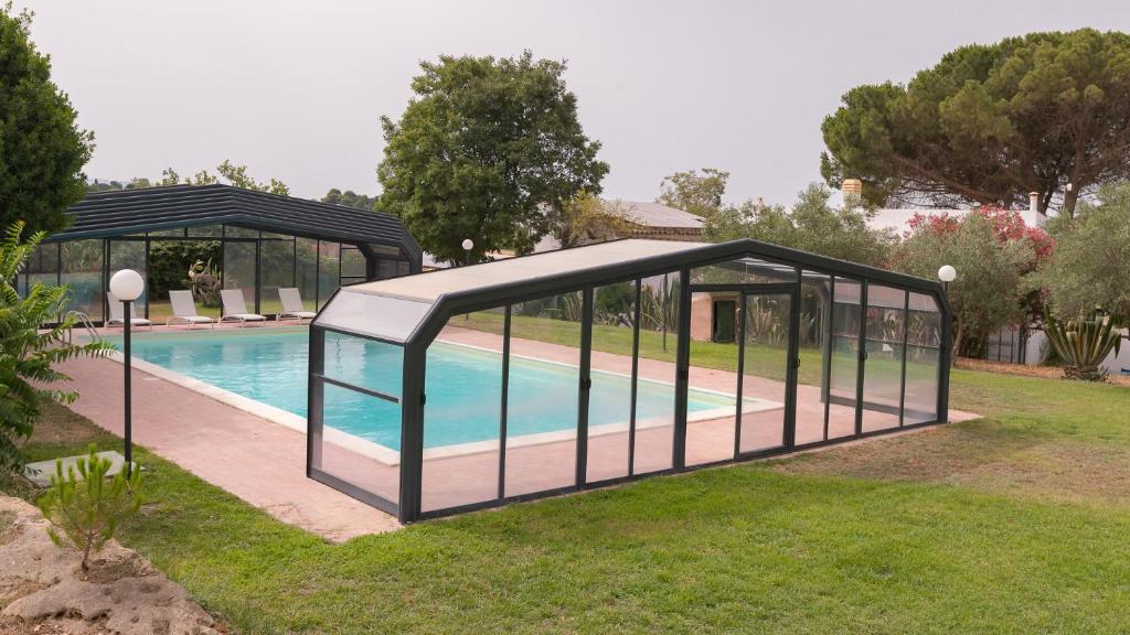 una piscina en un pabellón junto a una piscina en Villa Le Lune, en Santa Margherita di Belice