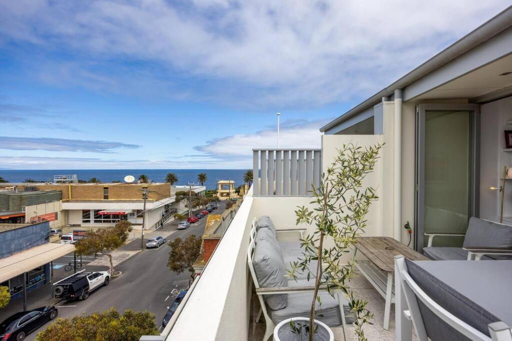 an apartment balcony with a view of a street at Sandy@Village - newly renovated + bay views in Sandringham