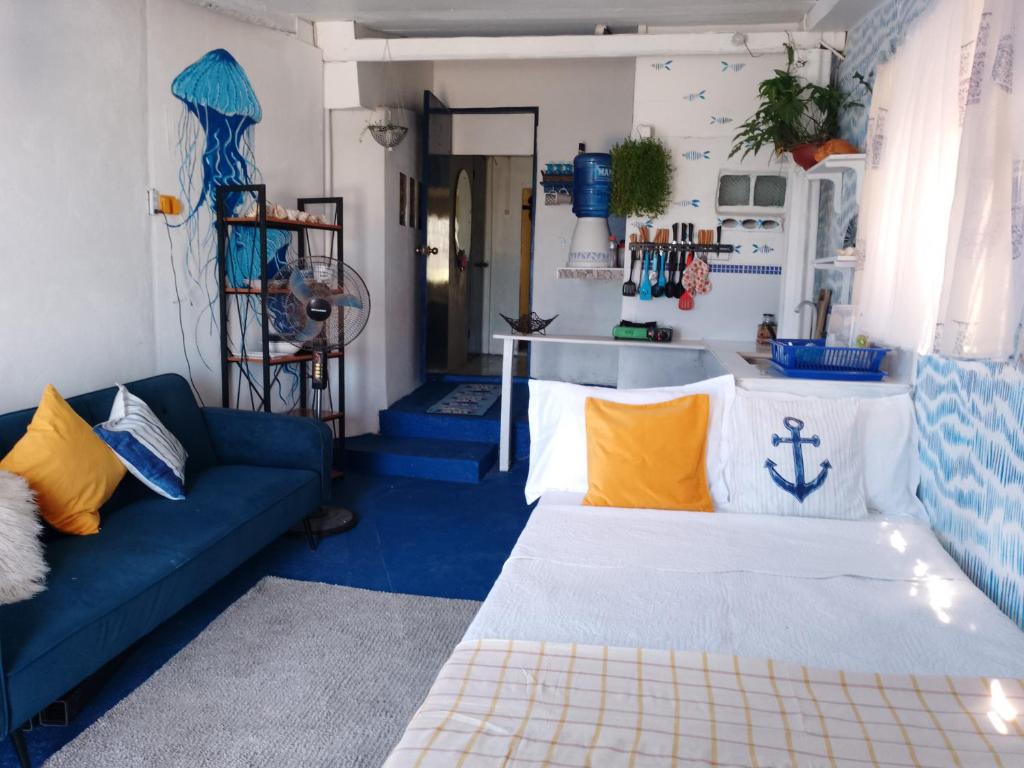 Daanbantayan的住宿－Little Sanity Beach house，客厅配有蓝色的沙发和黄色的枕头。