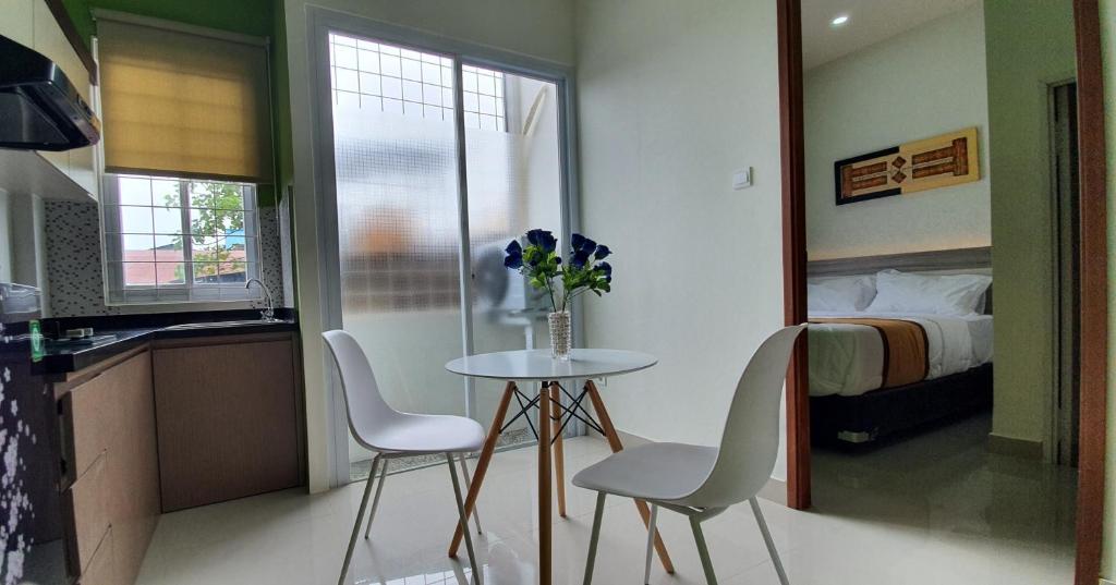 a small table and chairs in a room with a bed at REG GUESTHOUSE in Tanjungredep