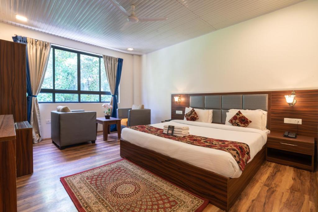 ein Hotelzimmer mit einem großen Bett und einem Fenster in der Unterkunft HOTEL SHINKHAM GRAND in Gangtok