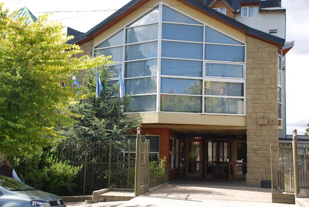 a house with large windows and a gate at Patagonia Sur Hotel in San Carlos de Bariloche