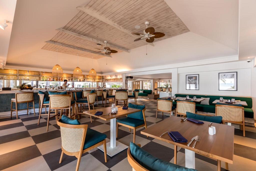 a restaurant with tables and chairs and a bar at Outrigger Koh Samui Beach Resort - SHA Extra Plus in Lamai