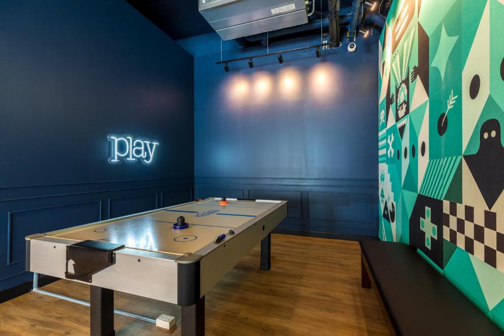a ping pong table in a room with a play sign at Outrigger Koh Samui Beach Resort - SHA Extra Plus in Lamai