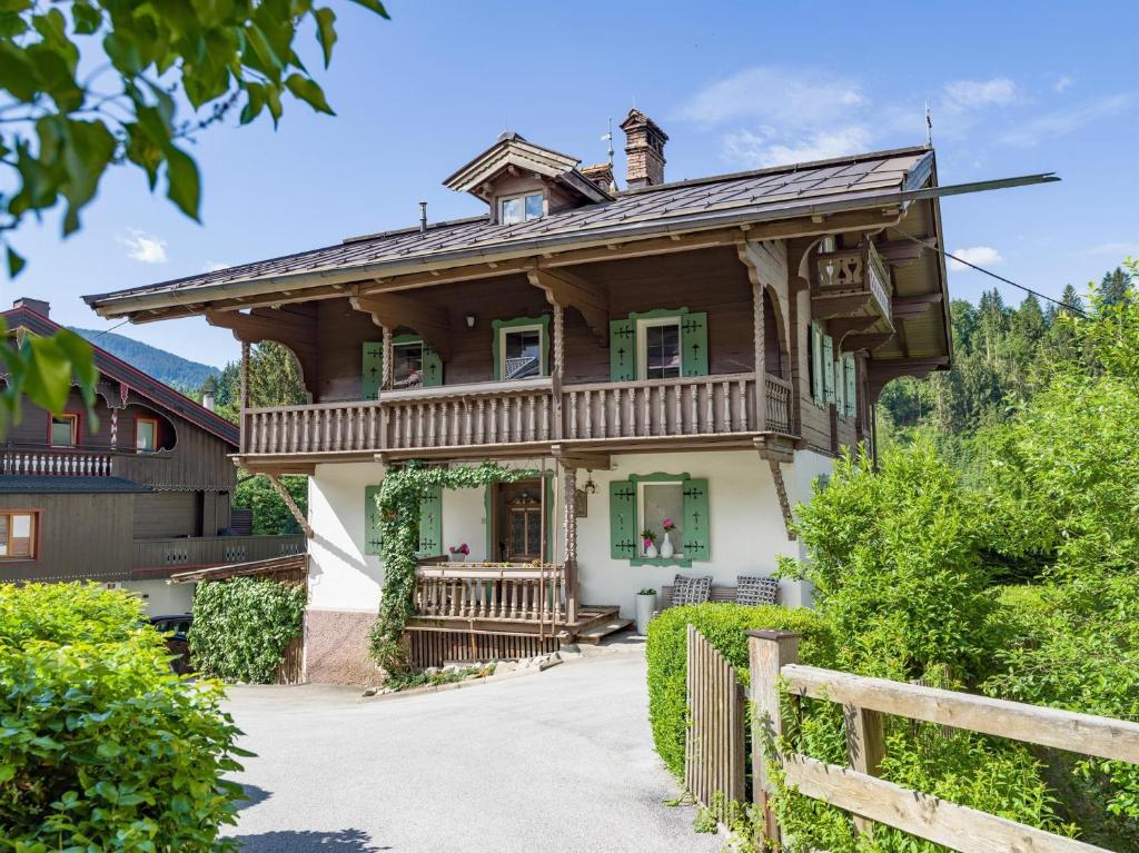 una casa de madera con una valla delante en Vintage Loft, en Hopfgarten im Brixental