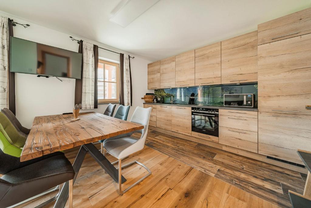 a kitchen with wooden cabinets and a wooden table and chairs at Dachstein West Apartment 1B in Russbach am Pass Gschütt