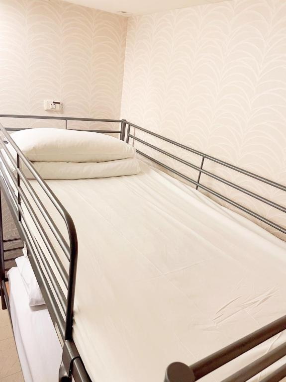 a bedroom with a bunk bed with white sheets at Single inn- KAOHSIUNG LINSEN in Kaohsiung