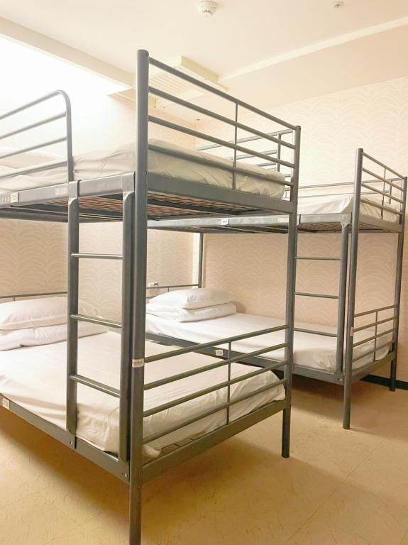 a couple of bunk beds in a room at Single inn- KAOHSIUNG LINSEN in Kaohsiung