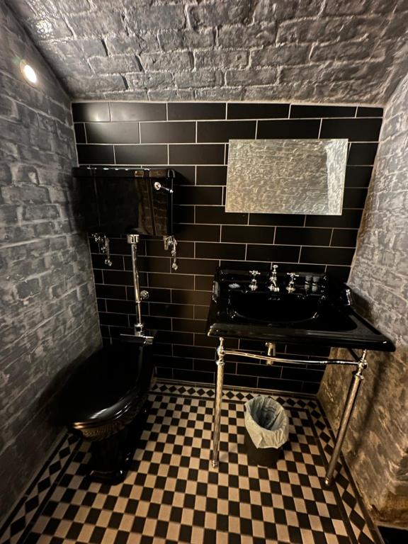 a black bathroom with a sink and a toilet at The Beetroot in Margate
