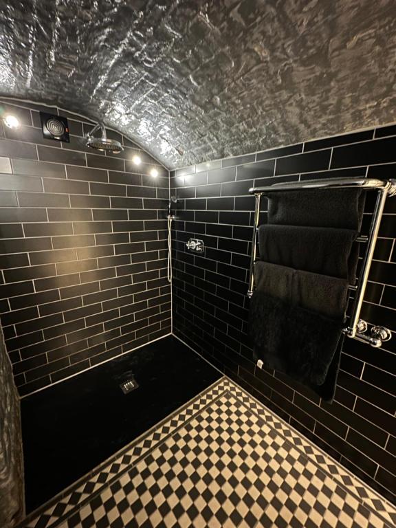 a black tiled bathroom with a black towel at The Beetroot in Margate