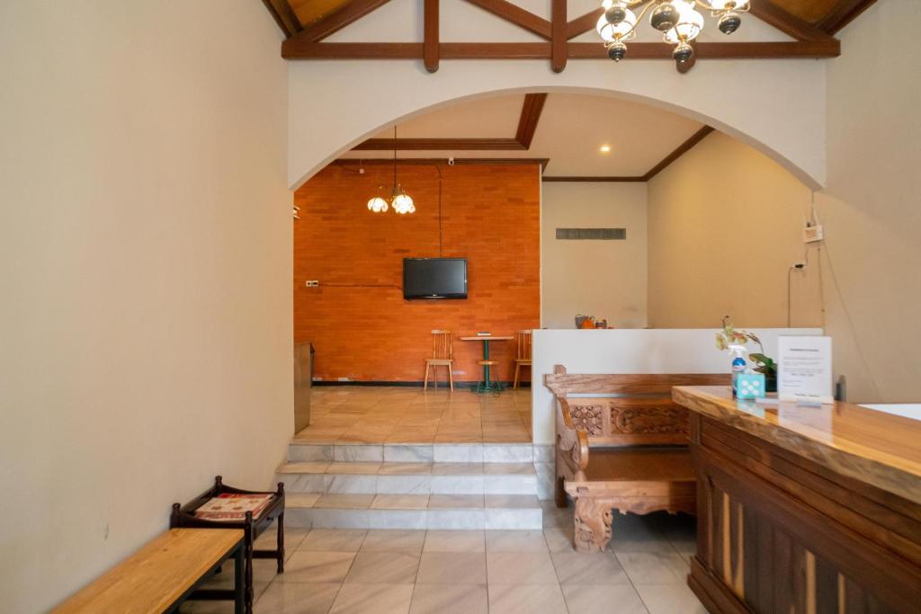 una grande camera con tavolo e TV a parete di Urbanview Hotel Bubusini Batu by RedDoorz a Batu