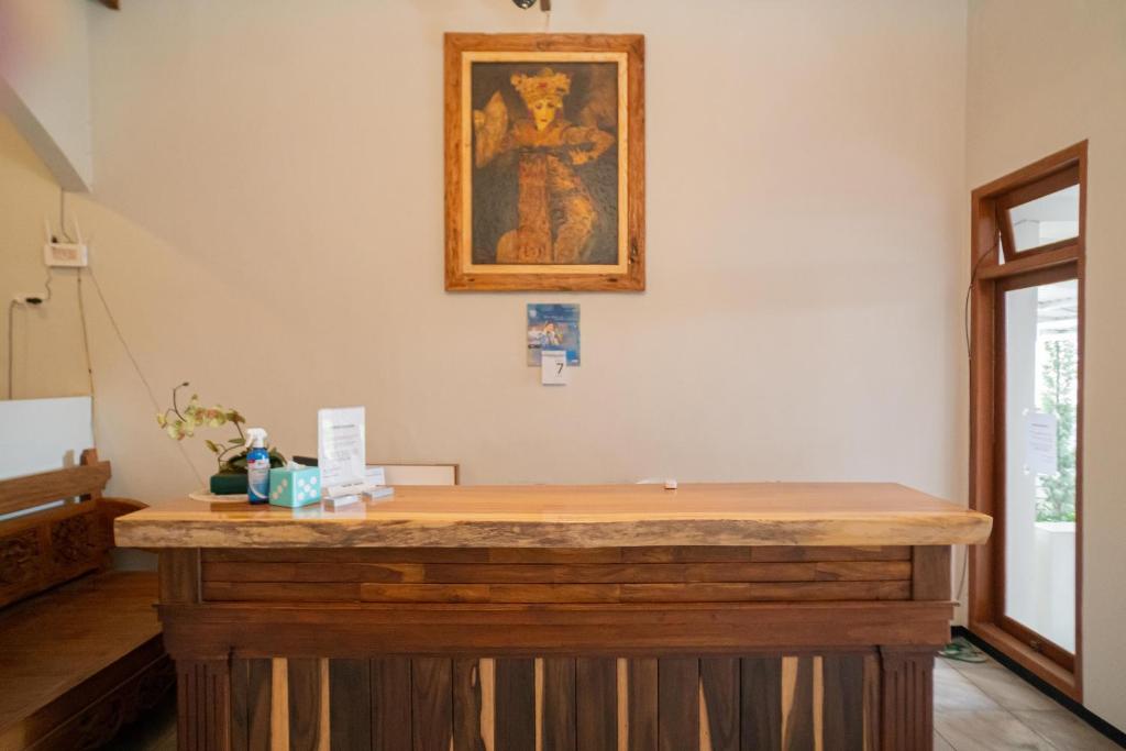 un bancone in legno in una stanza con un dipinto sul muro di Urbanview Hotel Bubusini Batu by RedDoorz a Batu