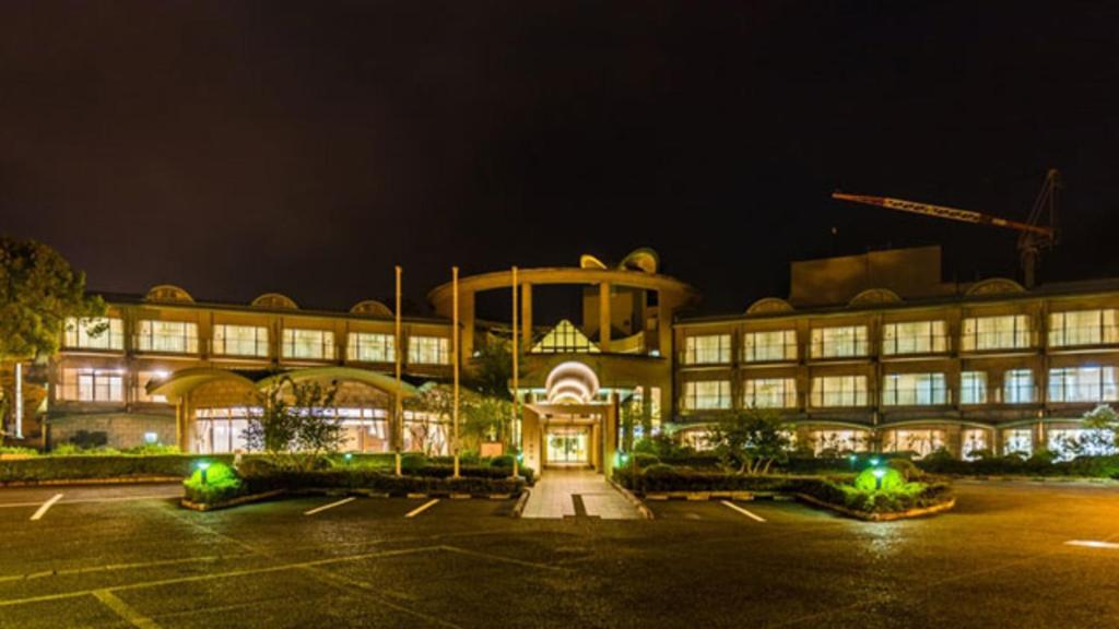 a large building with a parking lot at night at Kyukamura Oku-Musashi in Hanno