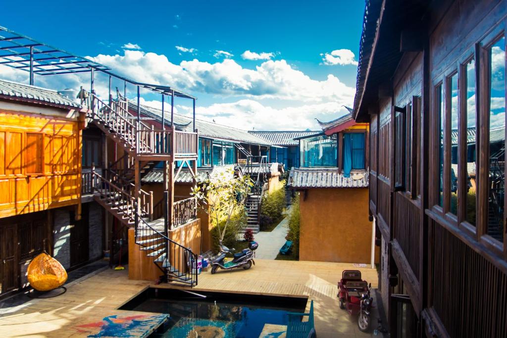 麗江的住宿－麗江背包十年青年公園青年旅舍，享有带游泳池和楼梯的建筑的景致