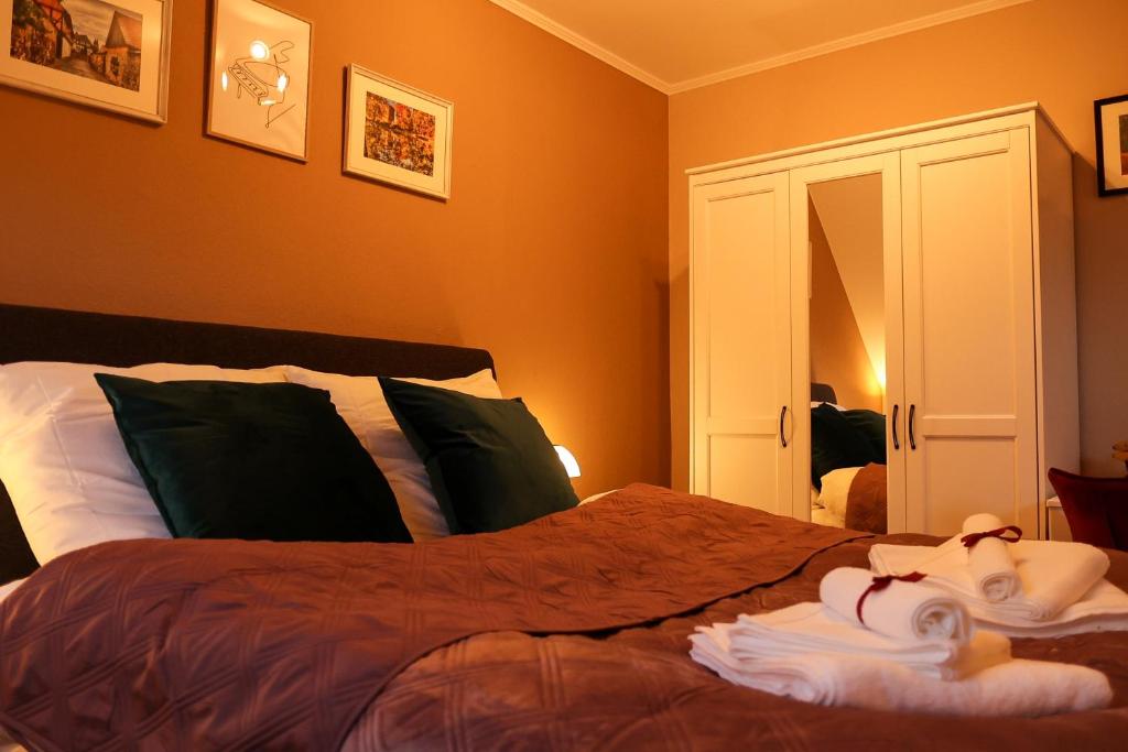 ein Schlafzimmer mit einem Bett mit orangefarbenen Wänden in der Unterkunft Apartment Serenade am Zwinger in Goslar