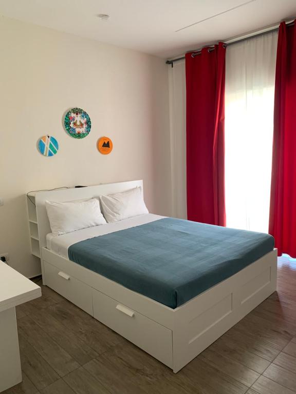 1 dormitorio con 1 cama grande y cortinas rojas en Residenza La Ciorta, en Nápoles
