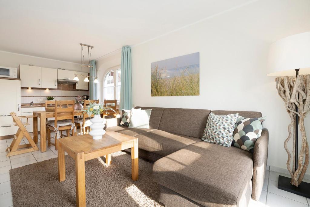 ein Wohnzimmer mit einem Sofa und einem Tisch in der Unterkunft Haus Pegasus App 4 in Scharbeutz