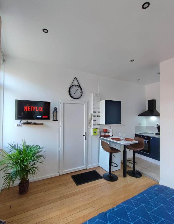 a kitchen with a table and a clock on the wall at Le Relax in Albert