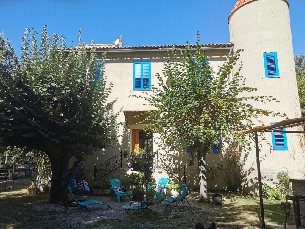 een huis met blauwe stoelen en bomen ervoor bij Casa Maria in Vico