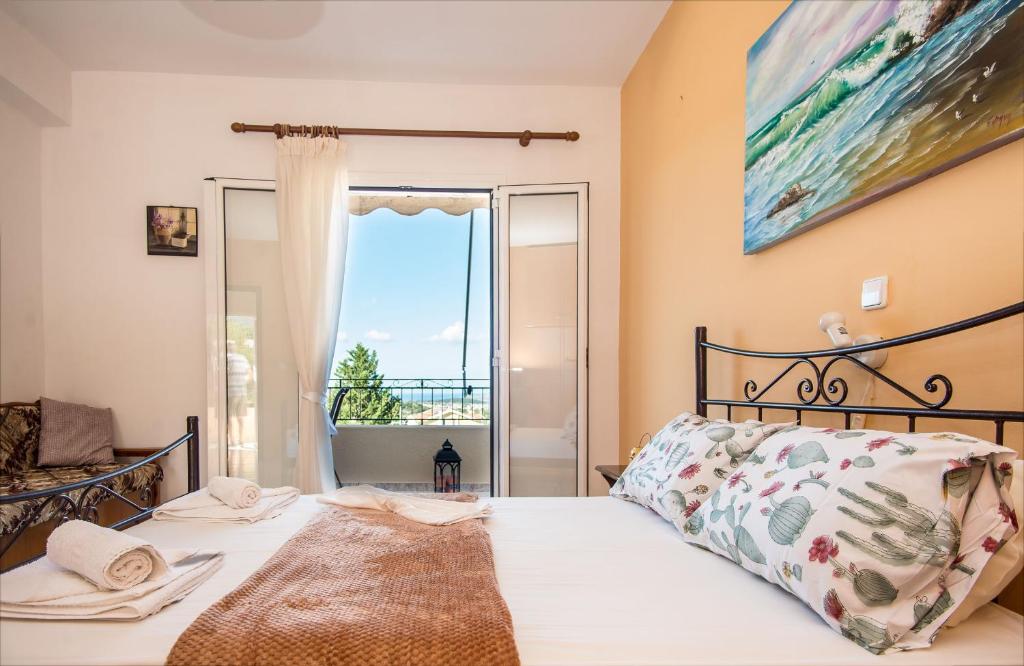 a bedroom with a bed and a large window at Aristotelis Apartments in Razáta