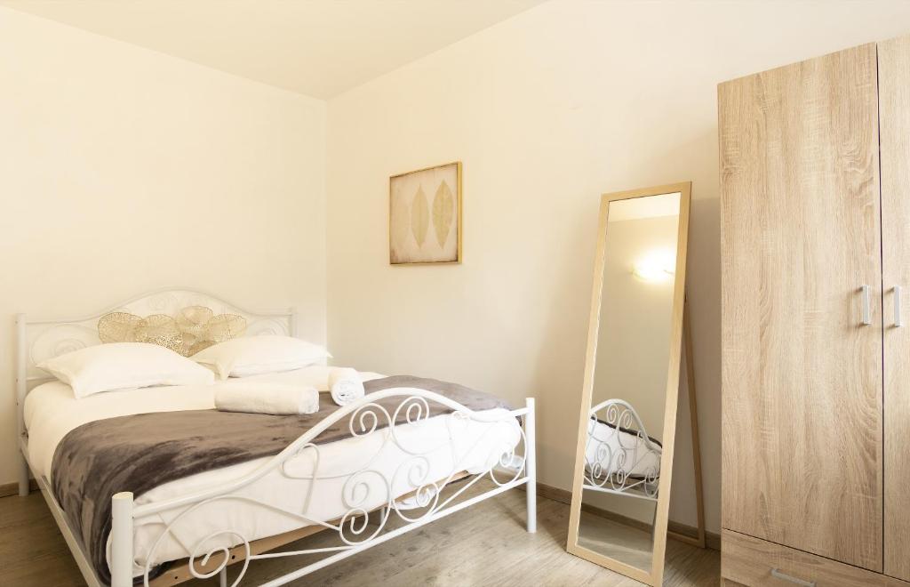 a white bedroom with a bed and a mirror at Joli T2 industrie hyper centre Annecy in Annecy