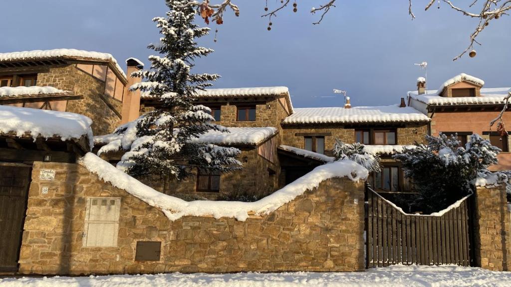 a snow covered building with a fence and a tree at La Vereda ONLY ADULTS in Mora de Rubielos