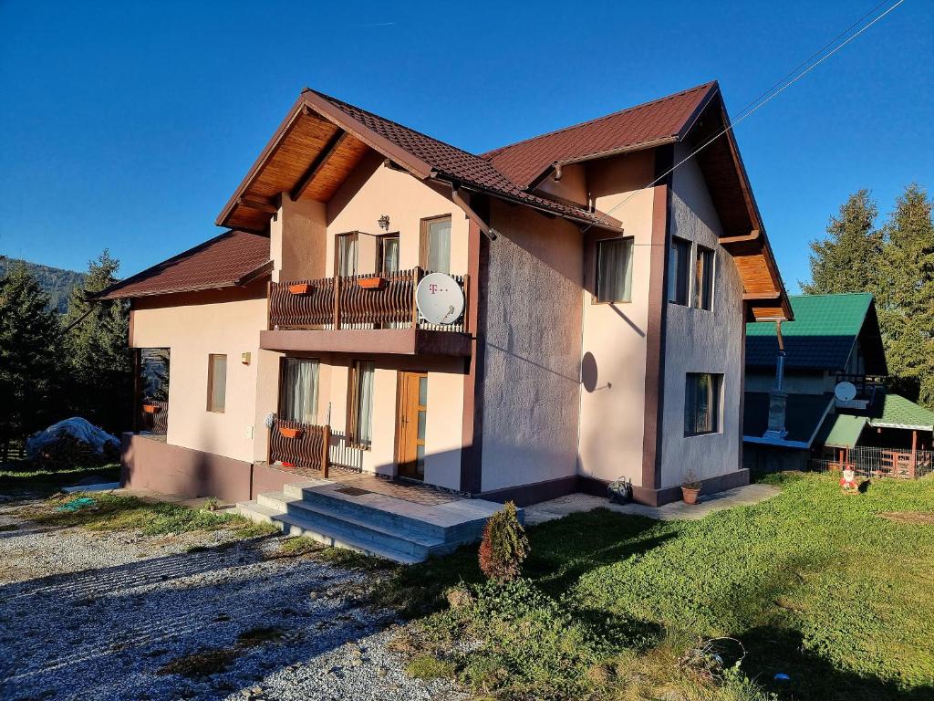 a small house with a porch and a balcony at Casa Dragomir in Plaiu Şarului