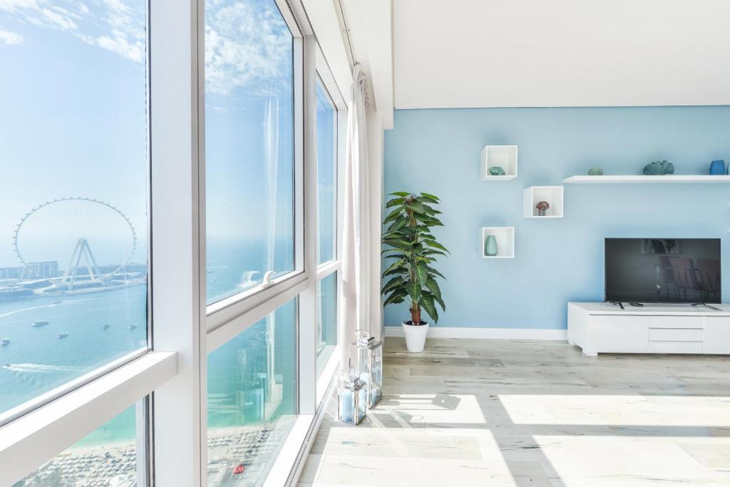 una camera con pareti blu e una grande finestra di Luxury JBR I Al Fattan Full Sea View I Free 5 star Beach Resorts Access a Dubai