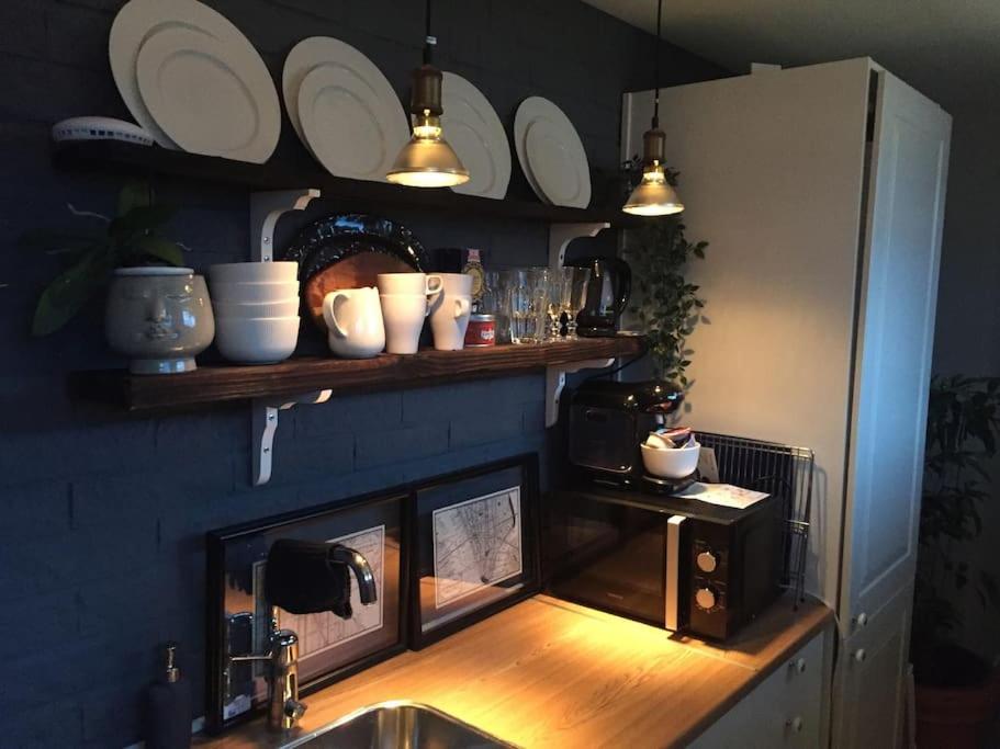 een keuken met een aanrecht met een magnetron en borden bij Stockholms home away from home in Stockholm