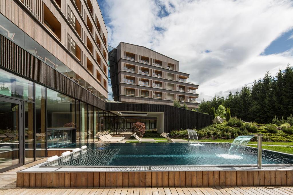 a swimming pool in front of a building at Falkensteiner Hotel Schladming in Schladming