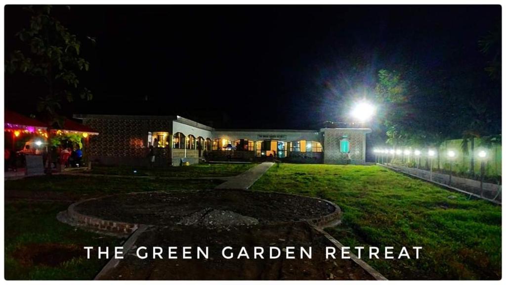 un giardino verde di notte con un lampione di The Green Garden Retreat, Dooars a Sukhani