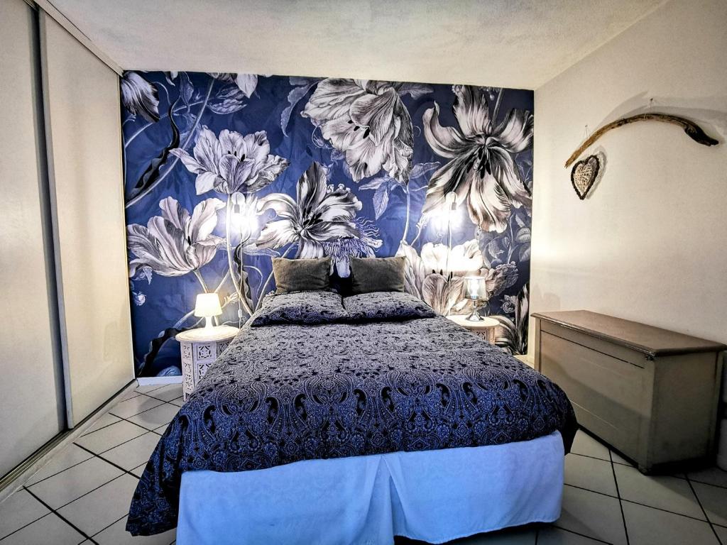 a bedroom with a bed with a blue and white wallpaper at La Bulle Bleue - Parking-Terrasse-aéoport-MEET in Blagnac