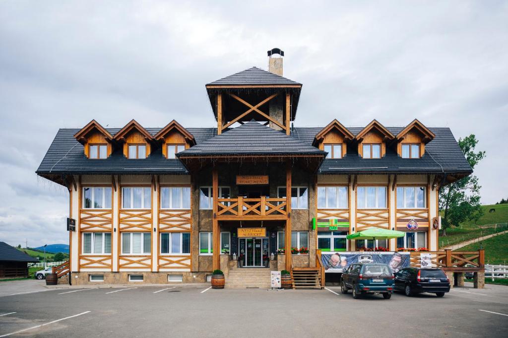 a large wooden building with a black roof at Nestville Apartments in Hniezdne