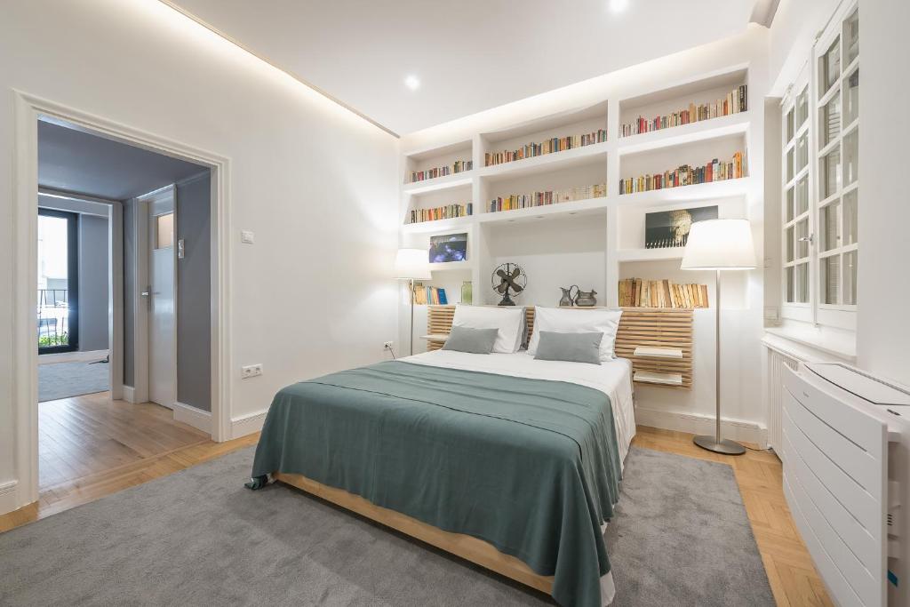 a white bedroom with a large bed and shelves at Charming apartment in Kolonaki in Athens