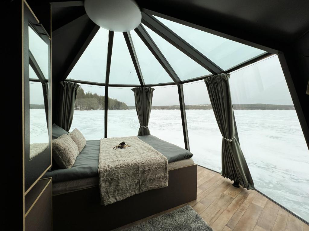 a bedroom in a boat with large windows at LakeLodge Kiehinen & Igloos in Rovaniemi
