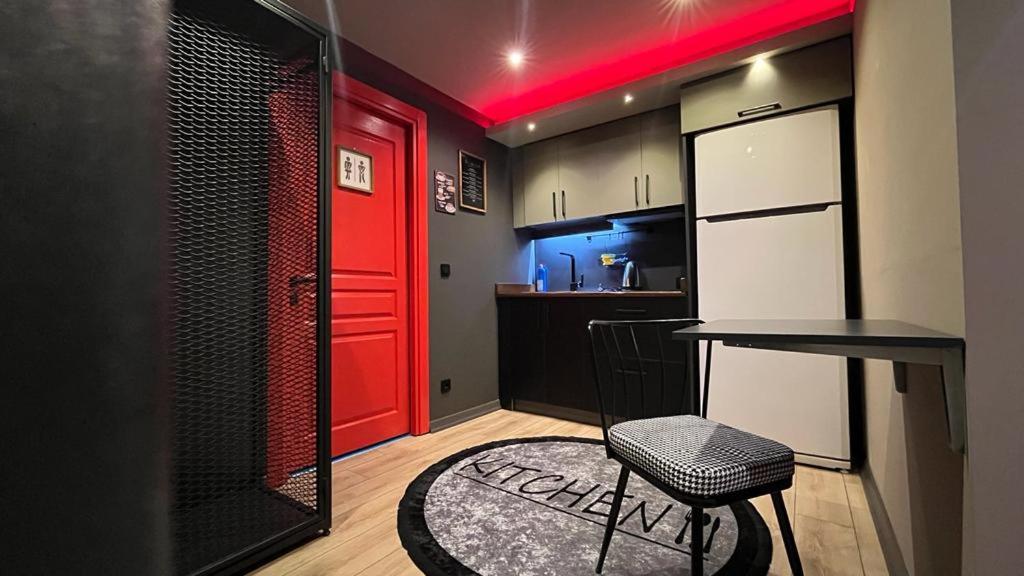 een keuken met een rode deur en een tafel en een kruk bij Thalia Suites Hotel in Istanbul