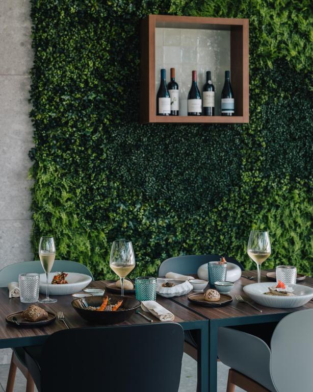 a table with plates of food and wine glasses at Porto Covo Praia Hotel & SPA in Porto Covo