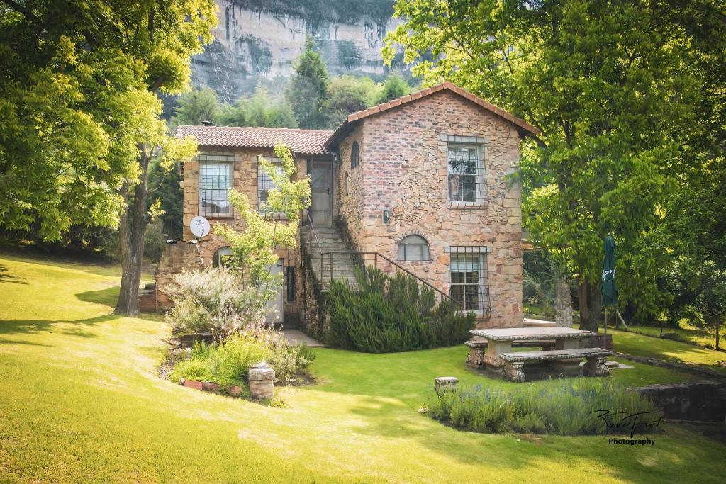 a stone house with a picnic table in the yard at The French Cottage in Clarens