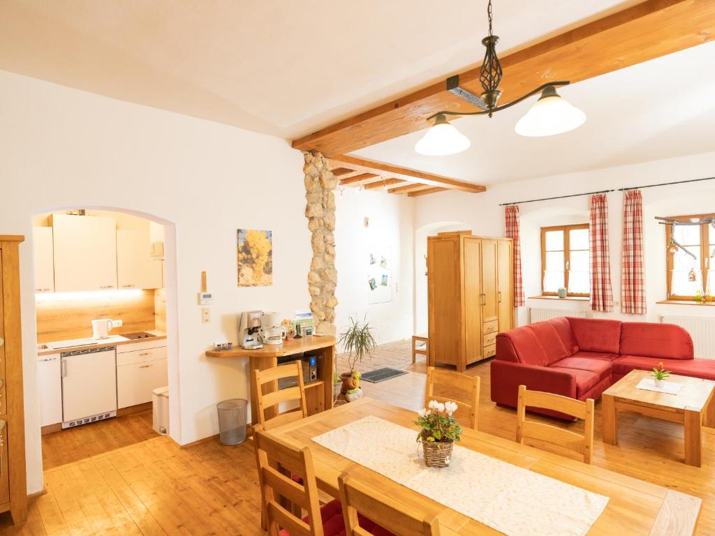 a living room with a red couch and a table at Ferienwohnung zum Kapuziner in Poysdorf