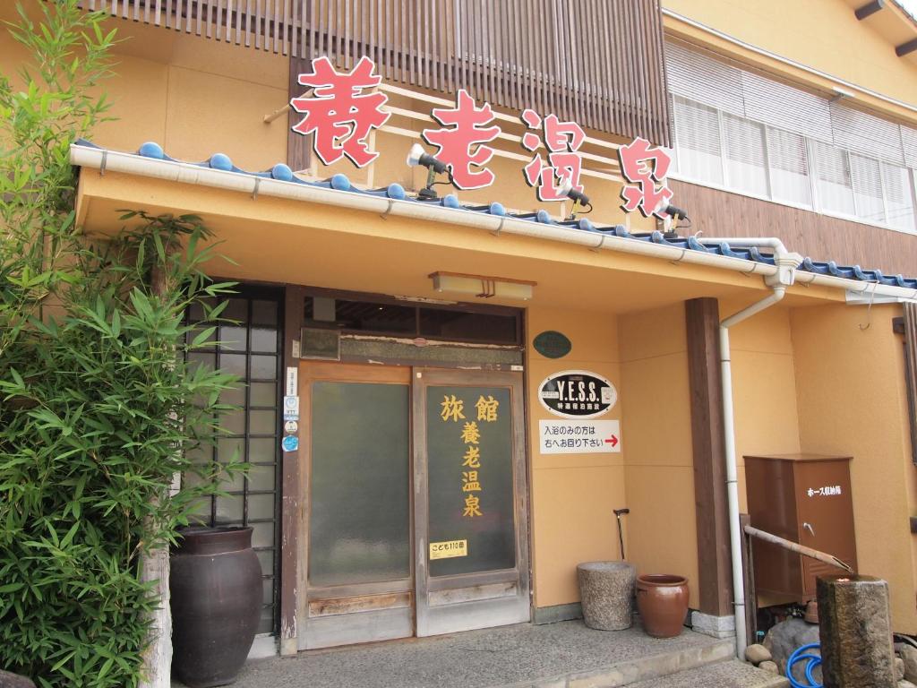 ein Gebäude mit Schildern auf der Vorderseite in der Unterkunft Yourou Onsen Honkan in Onomichi