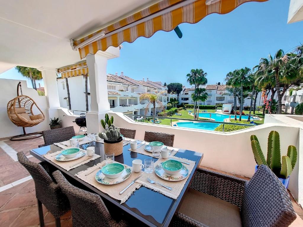 un tavolo da pranzo sul patio con vista sulla piscina di Renovated 2 bedroom Apt 5 min walk to beach RDR279 a Estepona