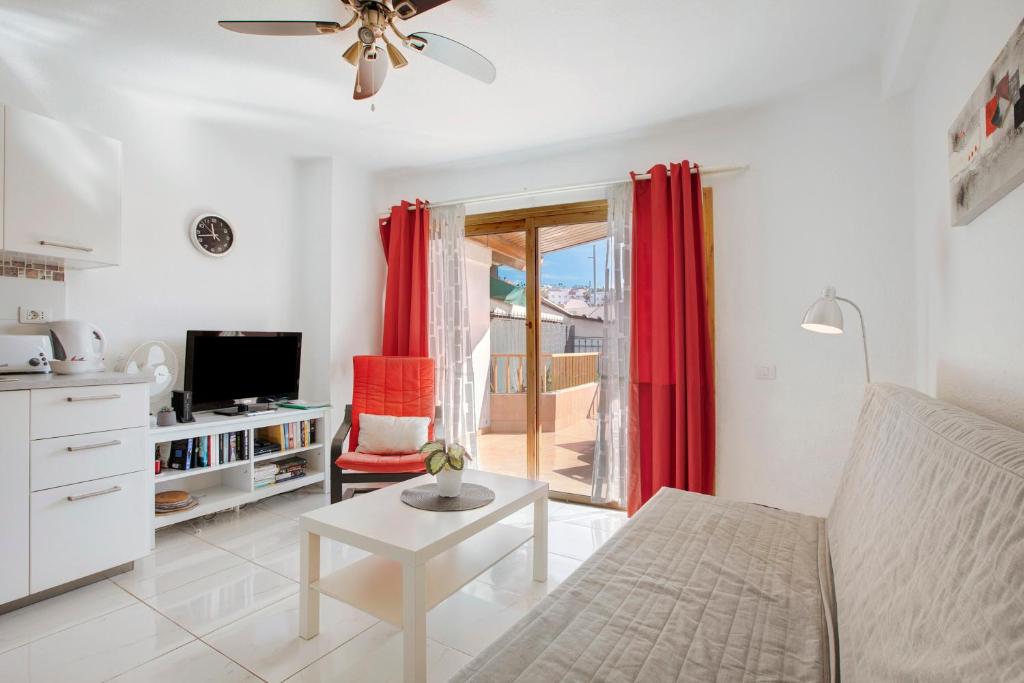 ein Wohnzimmer mit einem Sofa und einem TV in der Unterkunft Los Geranios 304 in Adeje