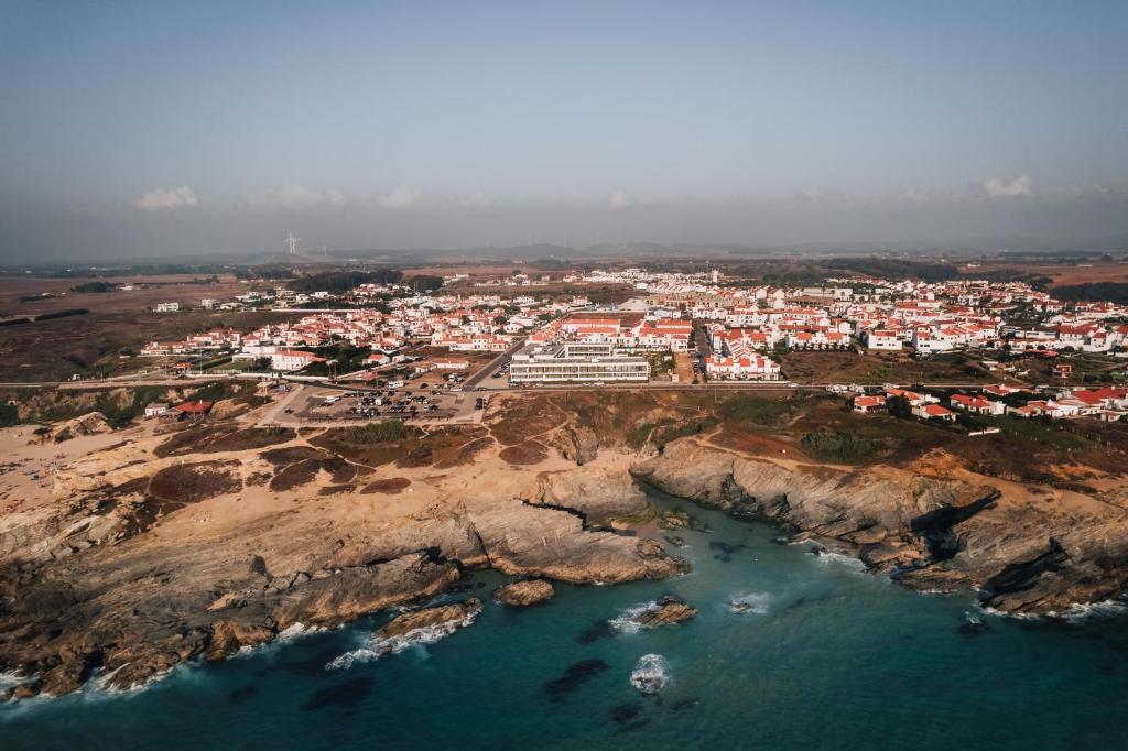 an aerial view of a town on a rocky coast at Porto Covo Praia Hotel & SPA in Porto Covo