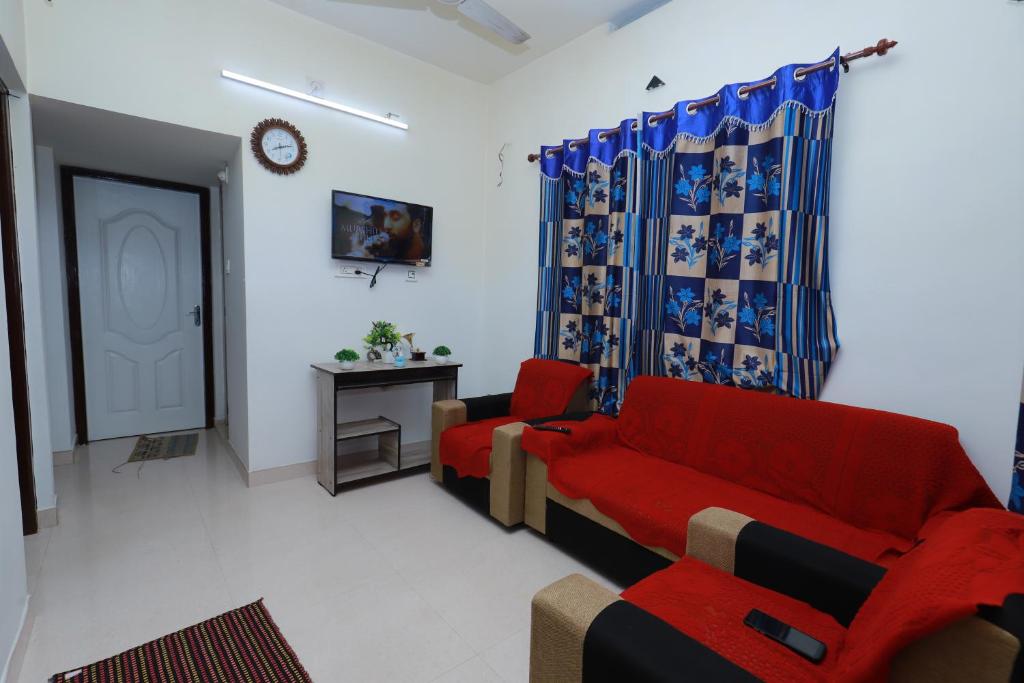 ein Wohnzimmer mit einem roten Sofa und einem Tisch in der Unterkunft 7coloursholidays in Kanthalloor