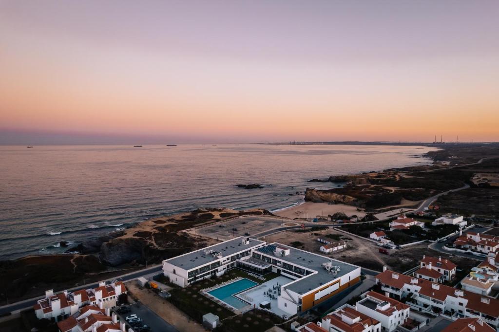 an aerial view of a city and the ocean at sunset at Porto Covo Praia Hotel & SPA in Porto Covo
